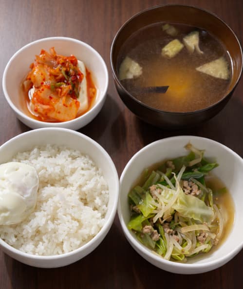 野菜炒め、味噌汁、豆腐、キムチ、ゆで卵、ご飯の夕飯の写真
